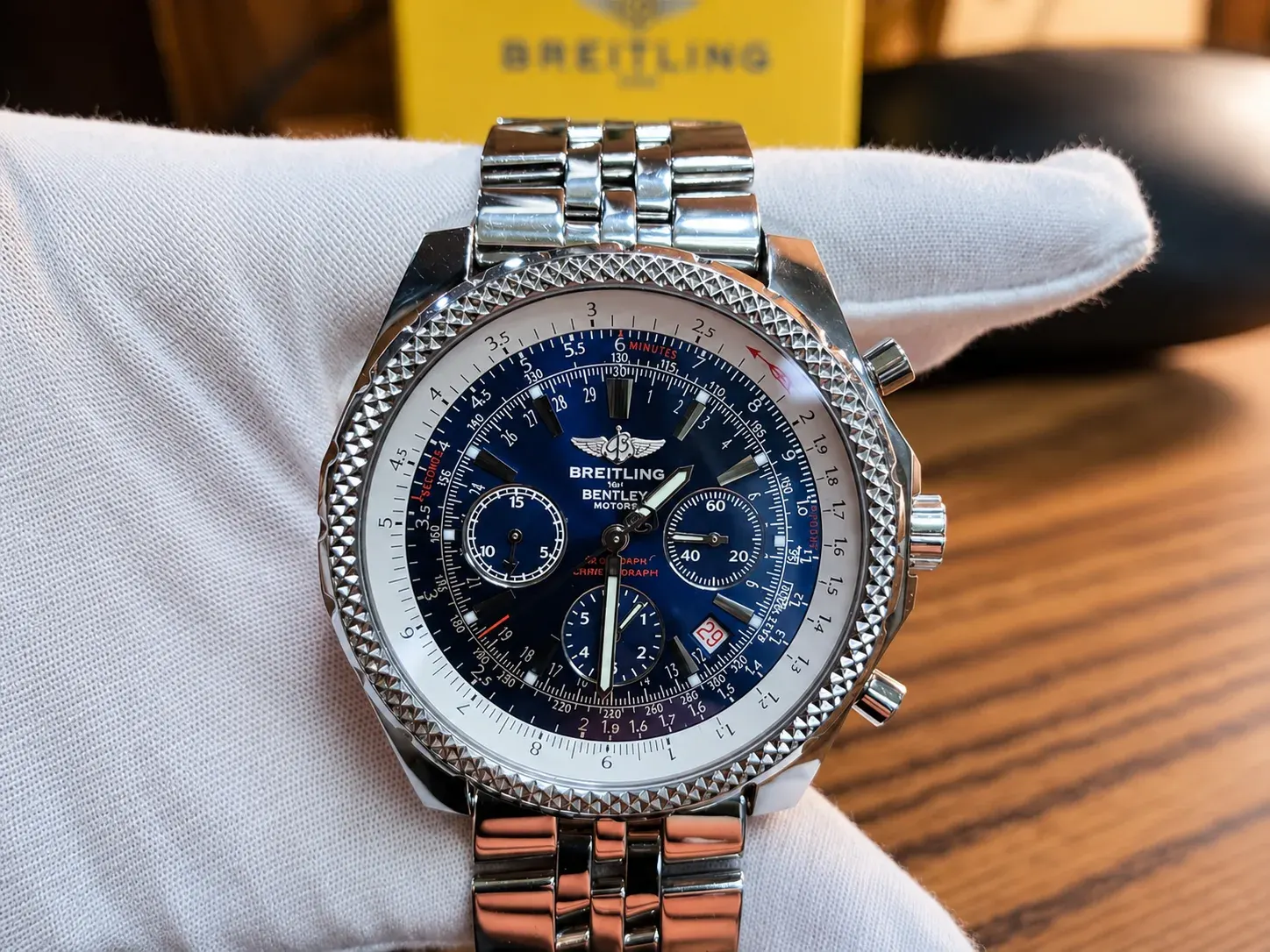 A Breitling Bentley Motors chronograph on a white cloth.