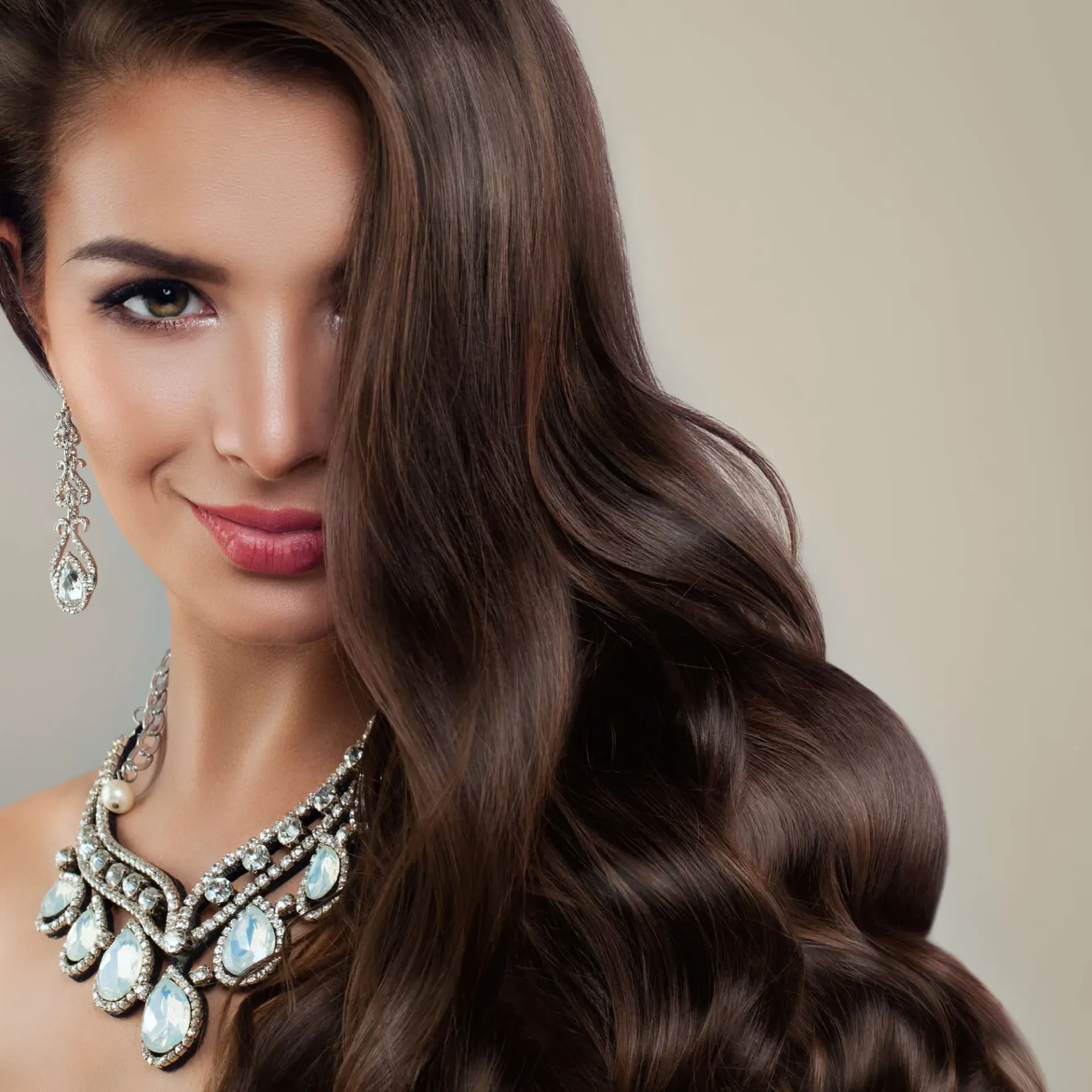 A model wearing a statement crystal necklace and chandelier earrings.