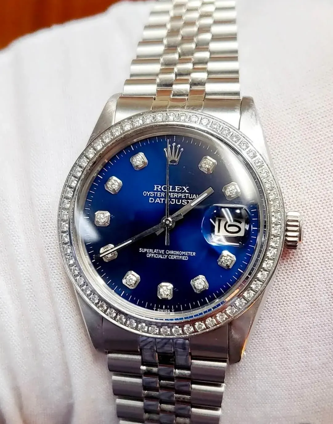 A stainless Rolex Datejust with a blue diamond-dot dial and diamond bezel.